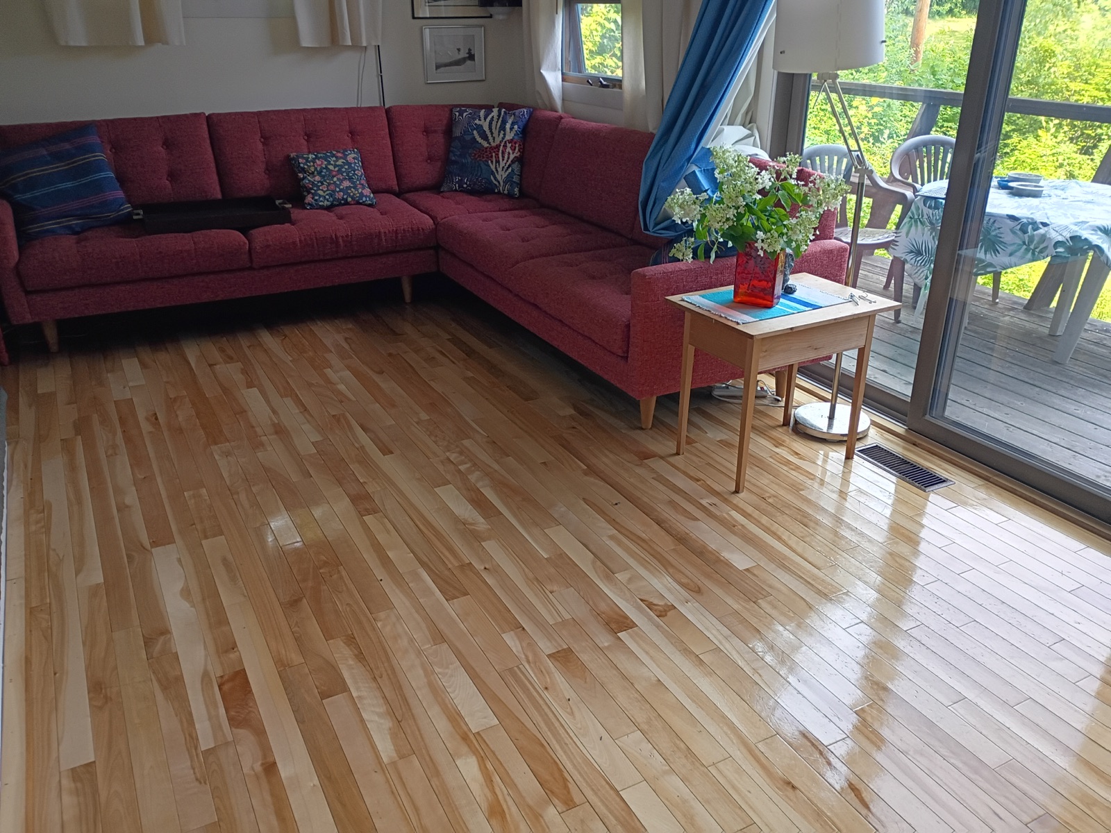 Clean living room with polished wood floors and deck access